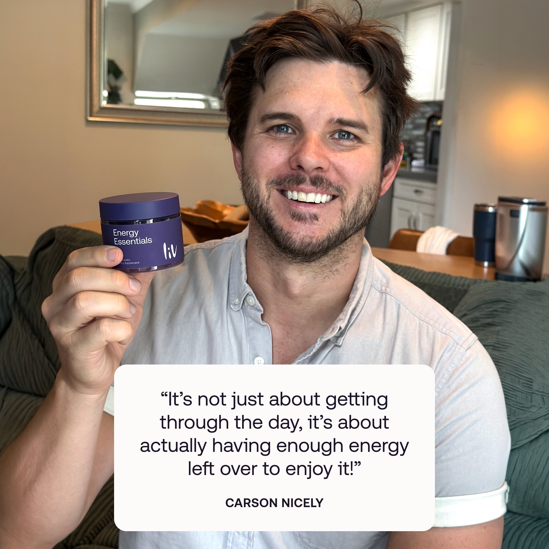 A smiling man in a light gray button-up shirt holds up a purple cosmetic jar labeled 'Energy Rechargeable' in a living room setting. A white text overlay features a quote attributed to Carson Nicely.