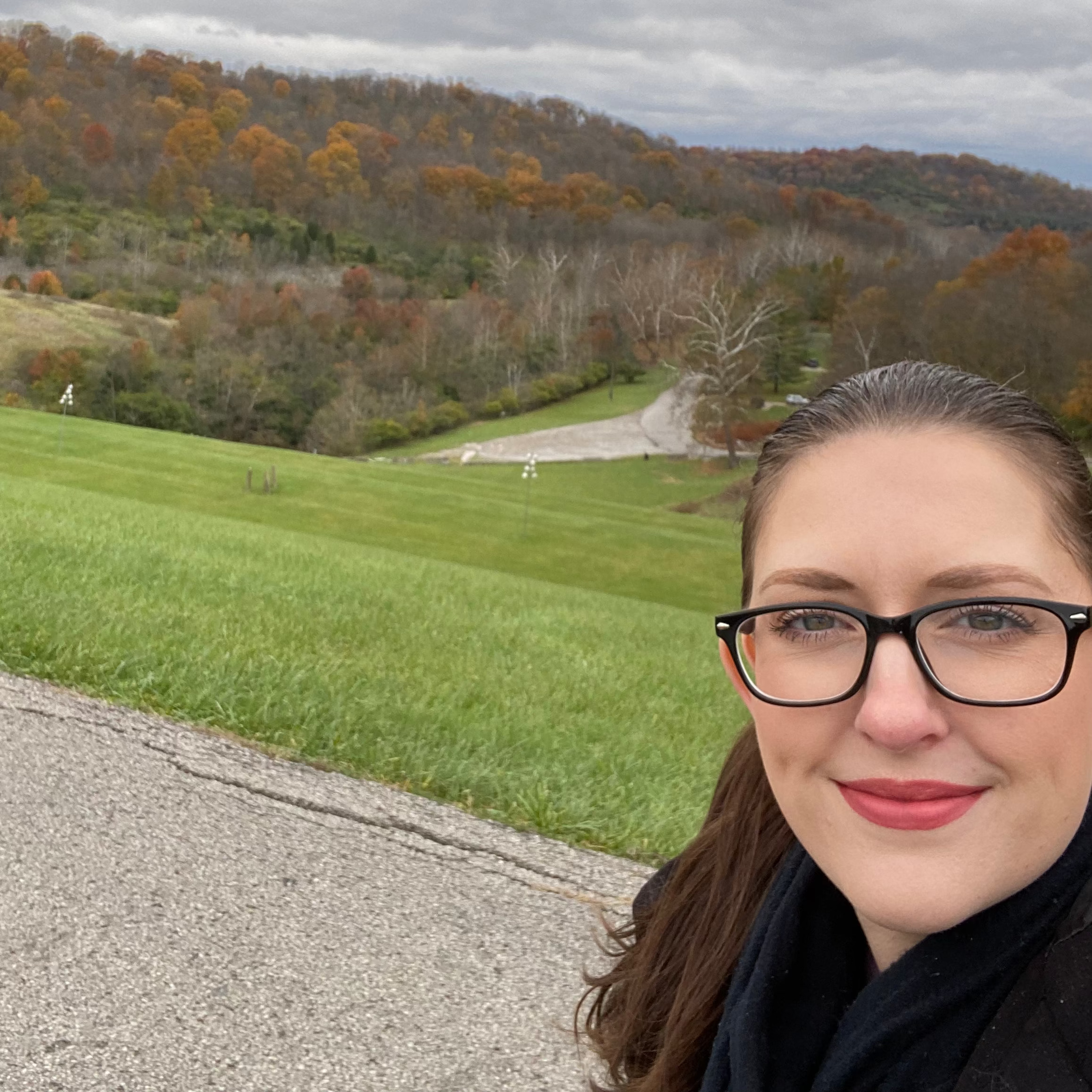 Jill Cappaert walking in the forrest with trees in the background - it looks like fall