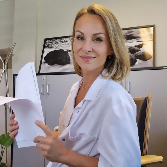 Katharina Pracon in a doctors jacket in a doctors office holding paper