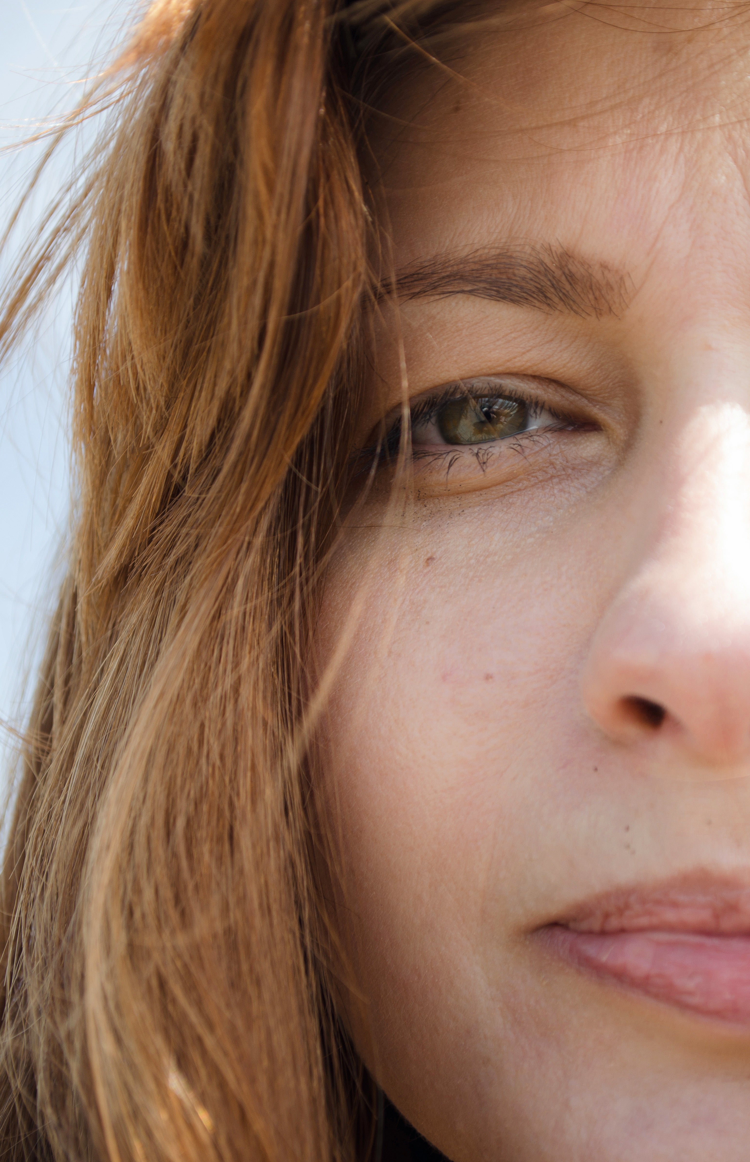 Close-up of a person with light brown hair and green eyes.
