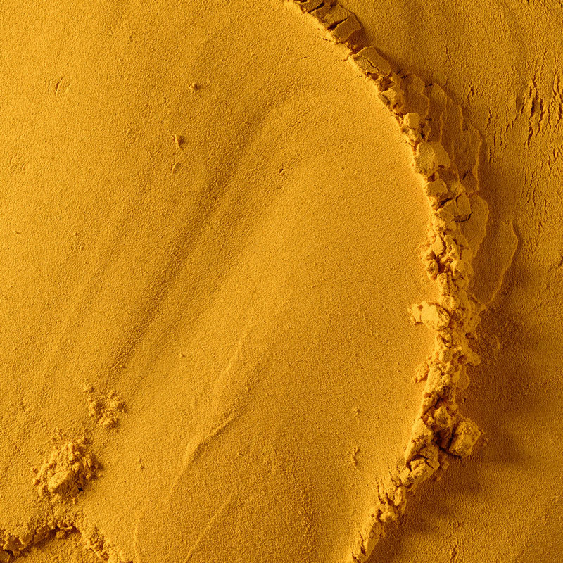 Close-up of a sand dune with a circular depression in a desert landscape