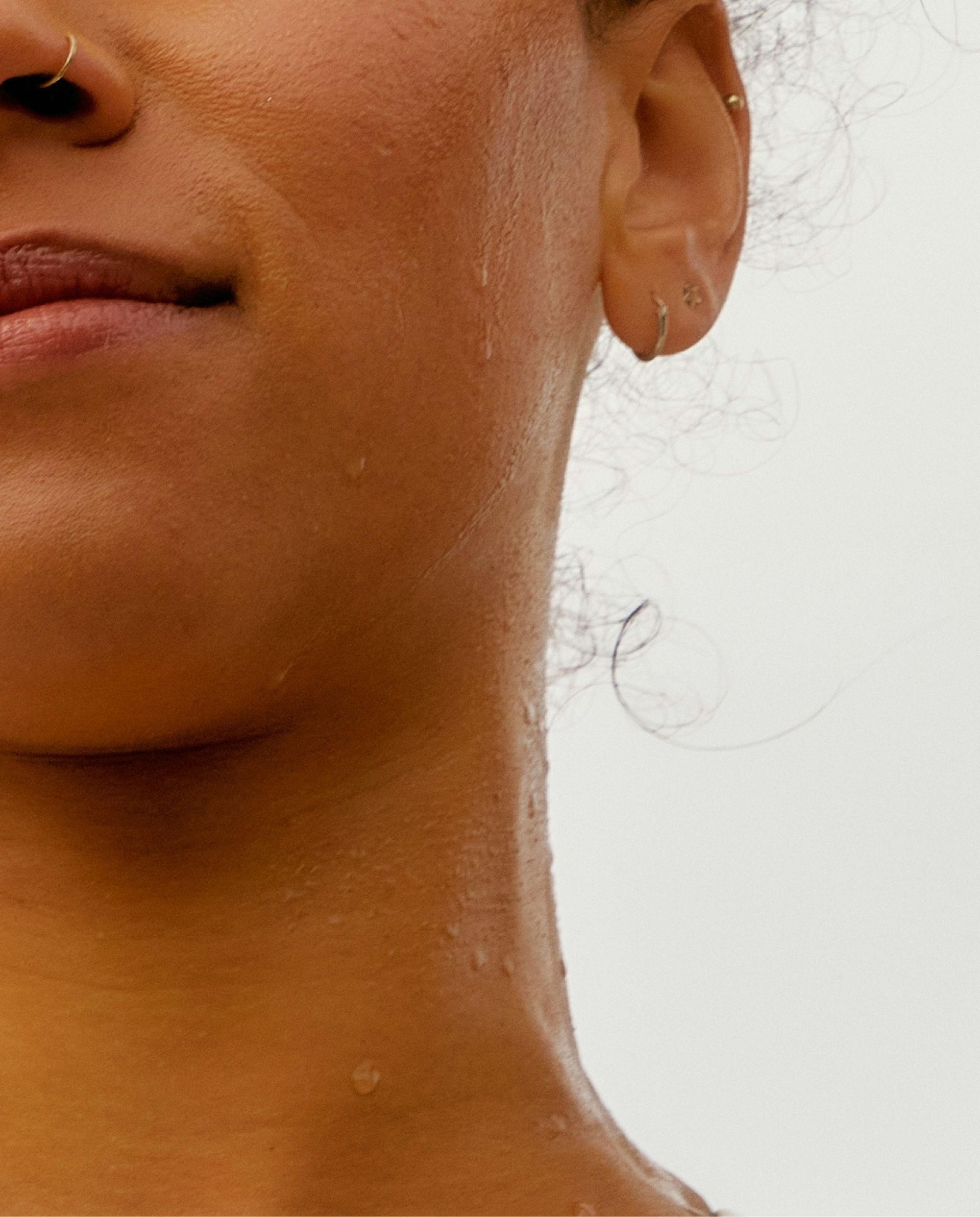 Close-up of a person's neck and ear with a neutral background